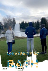 Three young people looking out over a lake.