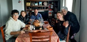 5 people (Nell and host family) sat around a dining table