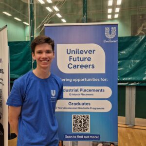 Ben standing next to a banner about Unilever careers. 