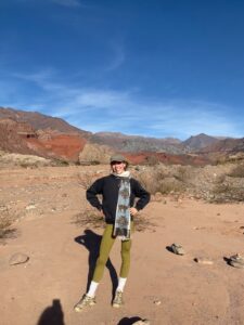 A person (Nell) stood in a red, sandy landscape in the Calchaquíes Valleys, Argentina