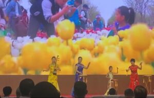 Women and child performing traditional Chinese music on stage