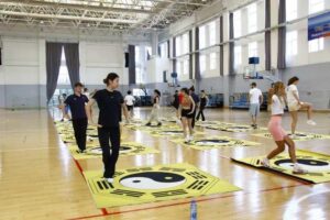 Summer school students practising Bagua Palm in large sports hall